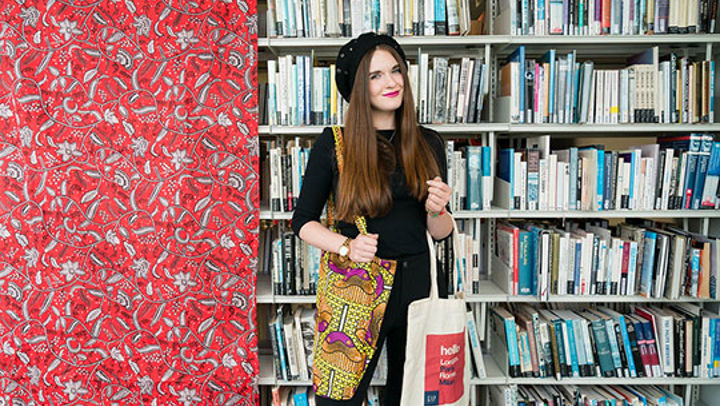 Student in front of bookshelf in QMU library